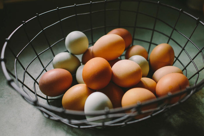 Many colorful chicken eggs in a basket